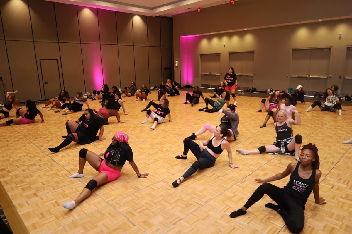 A ballroom full of dancers learning floorwork together
